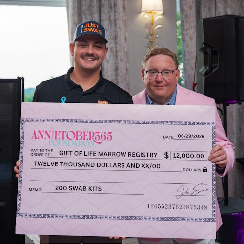 Gift of Life Marrow Registry Development Community Engagement Manager Alex Gonzalez (l), accepts a check for $12,000 from Andrew Eisner of the Annietober 365 Foundation.