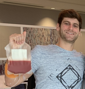 Jon holds up the bag of peripheral blood stem cells he donated to a cancer patient before the courier takes them to the transplant center. 