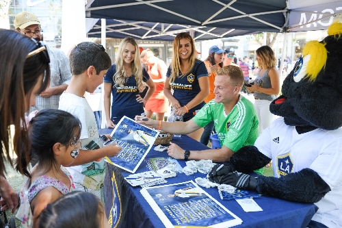 LA Galaxy goalkeeper Jon Kempin, mascot Cozmo and members of the Star Squad sign autographs for fans.