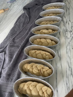 Braided loaves of challah are rising in their pans as Cayla Noorani prepares her weekly bake. 