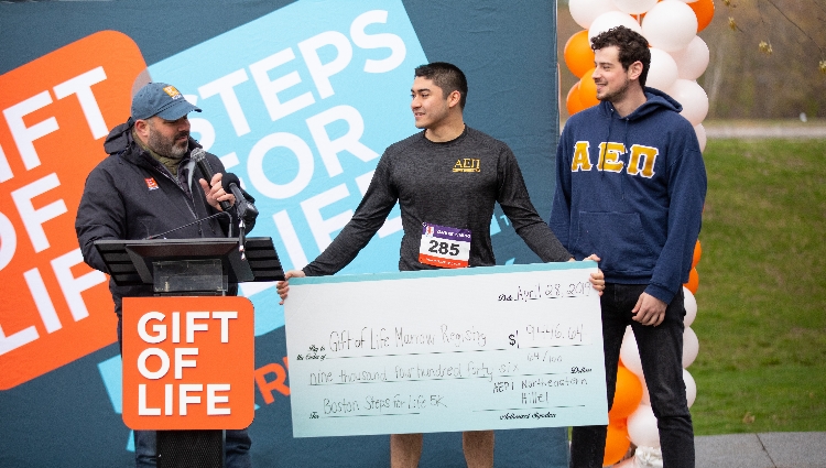 AEPi and Hillel presented a check from their annual fundraising river cruise.