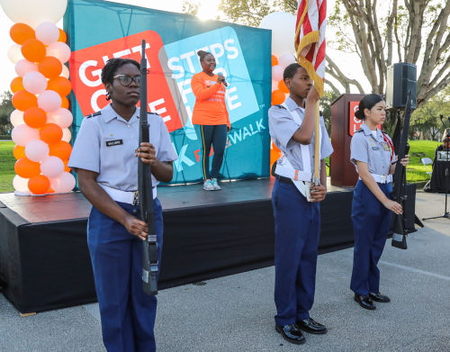 Gift of Life staffer Lensa Jeudy sings the national anthem as Coconut Creek High School JROTC provides the color guard.