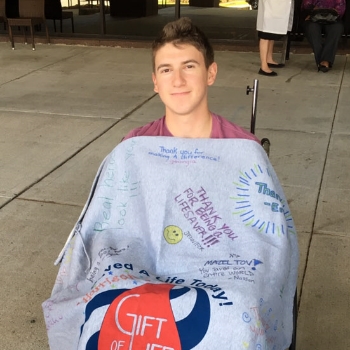 Bone marrow donor Harrison Cohn shows off his Gift of Life blanket on his day of donation. 