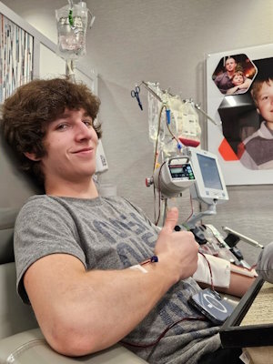 Gift of Life blood stem cell donor Nathan gives a thumbs up during his donation to help save the life of a 63-year-old man battling to survive leukemia.