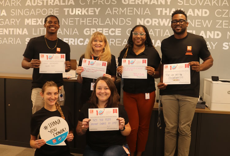 A group of Gift of Life staff members hold up World Marrow Donor Day messages thanking donors for their selfless gift of stem cells that save the lives of those battling blood cancer and more than 75 life-threatening diseases.