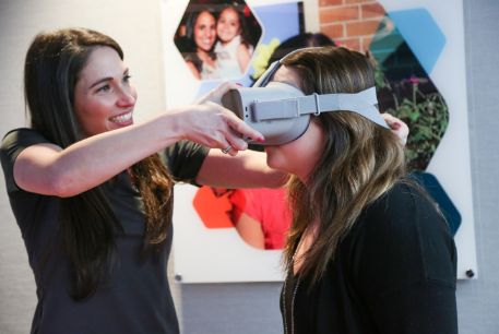 At Gift of Life's Adelson Collection Center, the donor concierge helps a stem cell donor set up an Oculus headset for entertainment while donating stem cells.